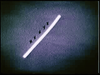 Historical film still showing a diagonal light bar and the experimenter marking response locations on the stimulus screen